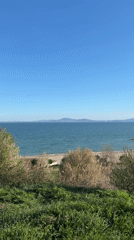 Two people rest on bench overlooking Burgas beach