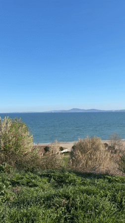 Two people rest on bench overlooking Burgas beach
