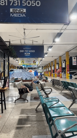 Passengers sleep on benches at Bangkok bus station