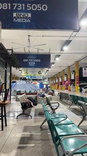 Passengers sleep on benches at Bangkok bus station