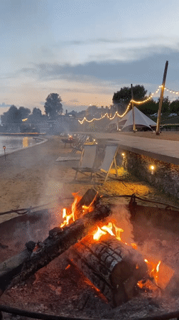 Evening beach resort scene with fires and lights in Votkinsk