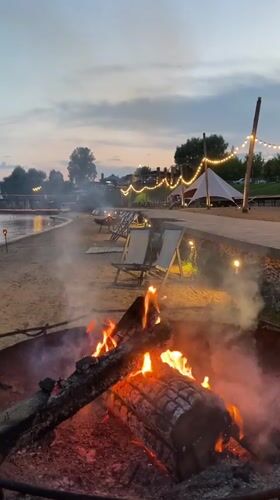 Evening beach resort scene with fires and lights in Votkinsk