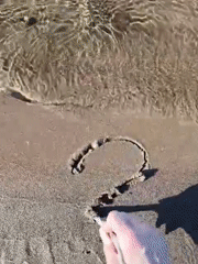 Visitor draws symbols in sand at Russian lakeside retreat