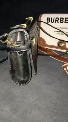 The video shows a dark surface with four purses on it. The purses are all different styles and materials. One is a black woven purse with gold hardware. Another is a white and brown Burberry purse with a brown strap. A third is a round straw purse with a colorful design. The fourth purse is blue and appears to be made of crocodile skin. The camera slowly moves across the purses, showing them in detail. The background is dark and out of focus.