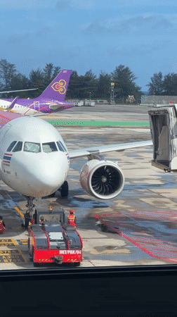 Phuket Airport tarmac activity on a rainy night