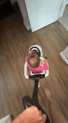 Toddler takes the wheel of a ride-on car indoors
