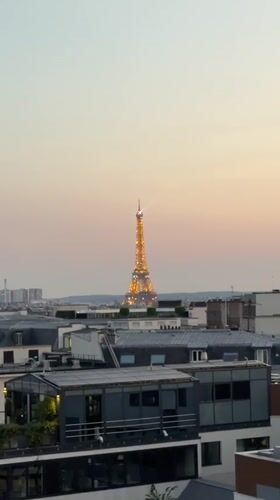 Rooftop drinks in Paris with the Eiffel Tower lit up at sunset.