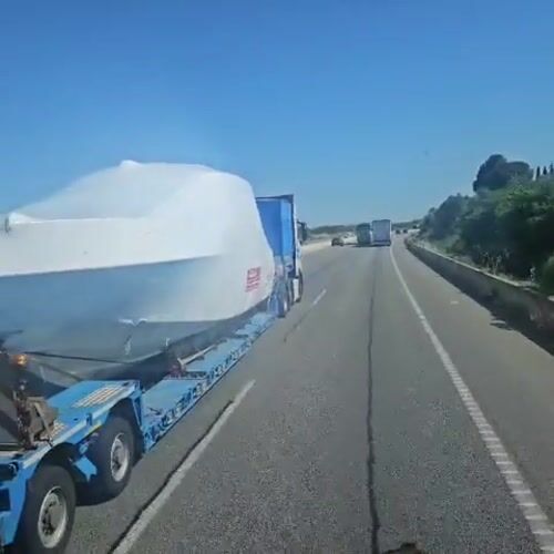 Truck transports covered boat on Spanish highway near Vilafant