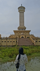 Visitors photograph Indonesian mosque complex from waterfront viewpoint
