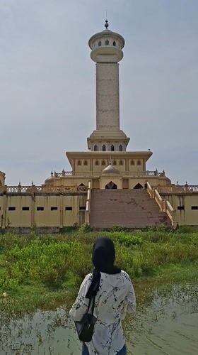 Visitors photograph Indonesian mosque complex from waterfront viewpoint