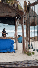 Two men sit beneath beach shelter in Playa del Carmen