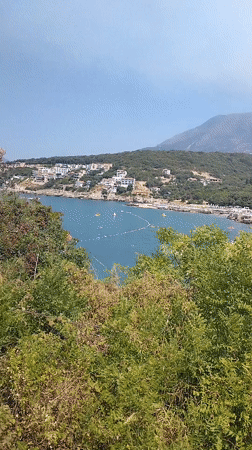 Wildfire on the hillside as swimmers enjoy Kunje's Adriatic bay