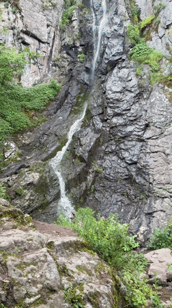 Tourists visit waterfall in Ustina, Bulgaria amid overcast skies