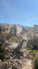 Excavator demolishes damaged building in Budva, Montenegro