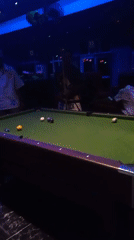 Man plays pool at dimly lit bar in Lokoja