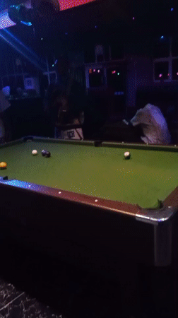Man plays pool at dimly lit bar in Lokoja