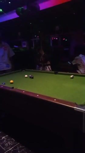 Man plays pool at dimly lit bar in Lokoja
