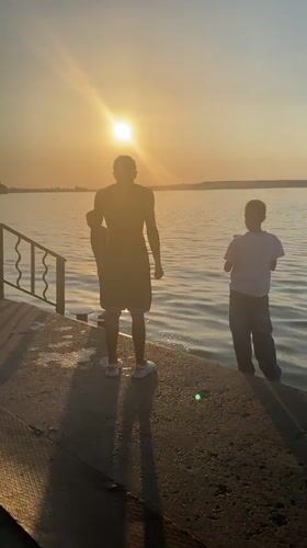 Sunset on a Votkinsk pier, figures watching the water