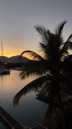 Dusk settles over Victoria's harbor, sailboats still at anchor
