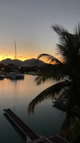 Dusk settles over Victoria's harbor, sailboats still at anchor