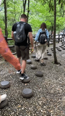 Tourists explore scenic stone pathways amid rock formations in Xiehe