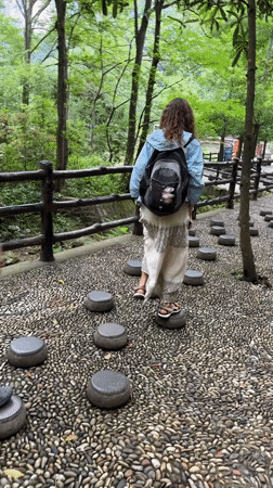 Tourists explore scenic stone pathways amid rock formations in Xiehe