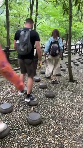 Tourists explore scenic stone pathways amid rock formations in Xiehe