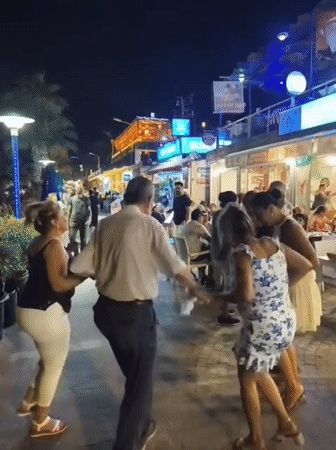 Circle dancing on a lively Kuşadası promenade at night