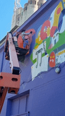 Artist paints cartoonish mural on purple building in Saarbrücken