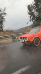 Red Volkswagen drives through rain in Naucalpan de Juárez