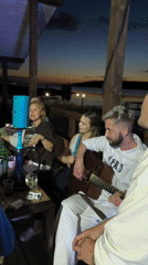 Acoustic guitar session on a lit patio at dusk, Chaikovsky