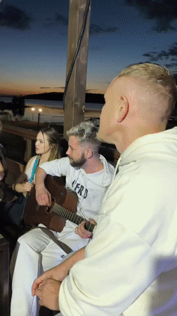 Acoustic guitar session on a lit patio at dusk, Chaikovsky