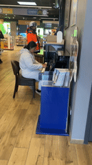 Woman plays digital piano in French service station store