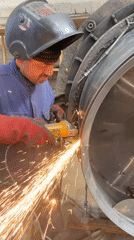 Worker grinds metal with safety gear in Tomba, Montenegro