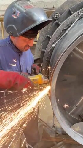 Worker grinds metal with safety gear in Tomba, Montenegro