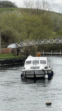 Cabin cruiser navigates canal lock near Little Wittenham bridge