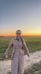Woman poses in sunset field near Saint Petersburg