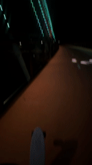 Skateboarder in purple Crocs crosses illuminated Perth pedestrian bridge