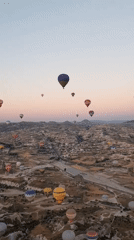 Mass balloon launch over Cappadocia's rock formations at dawn