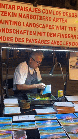 Street artist paints as twilight settles over La Concha Beach