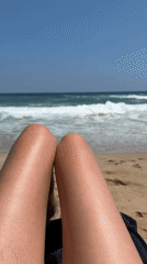 Relaxing beachside with legs out, ocean in view