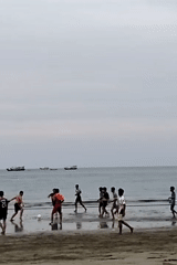 Young men play beach football in Lhokseumawe, Indonesia