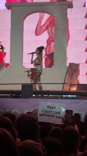 Live stage performance with bold visuals and a pink backdrop