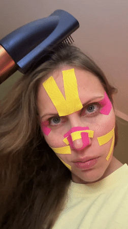 Woman applies kinesiology tape to face in Fethiye home