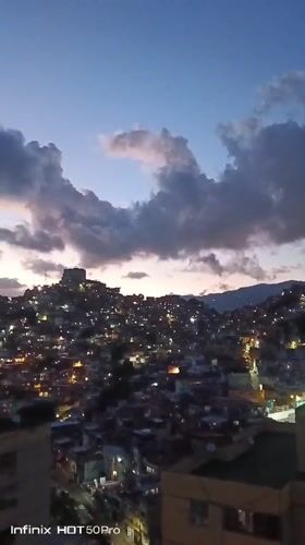 Caracas at dusk: hillside city, a macaw, and evening light