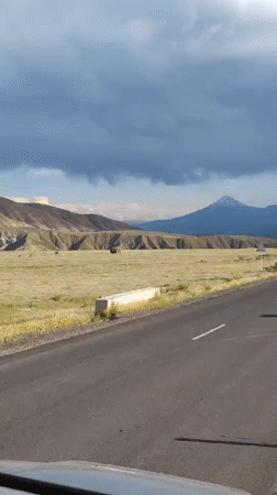 Road trip through Armenian plains toward a snow-capped peak
