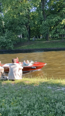 Relaxing by the water as a red motorboat passes by