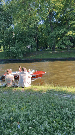 Relaxing by the water as a red motorboat passes by