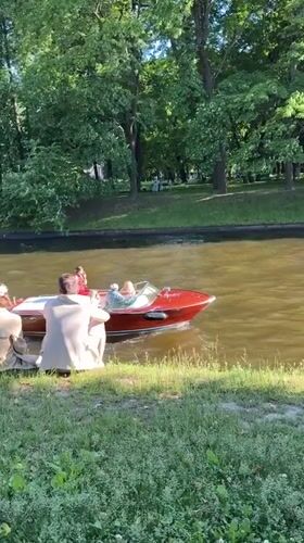 Relaxing by the water as a red motorboat passes by
