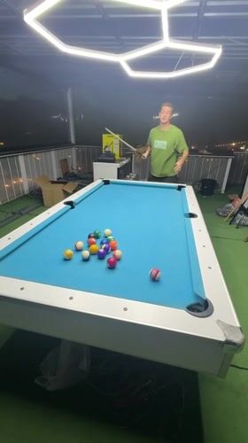 Man plays outdoor pool in Thailand terrace overlooking cityscape